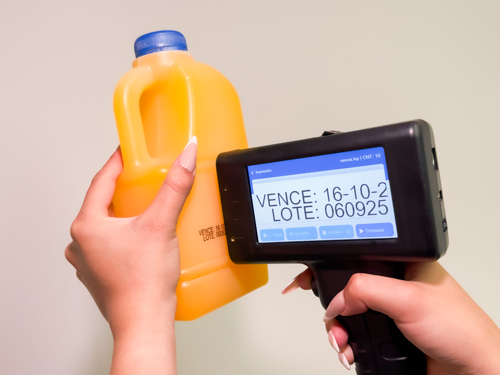 Codificadora inkjet portátil imprimiendo fecha de vencimiento y lote sobre un envase de jugo