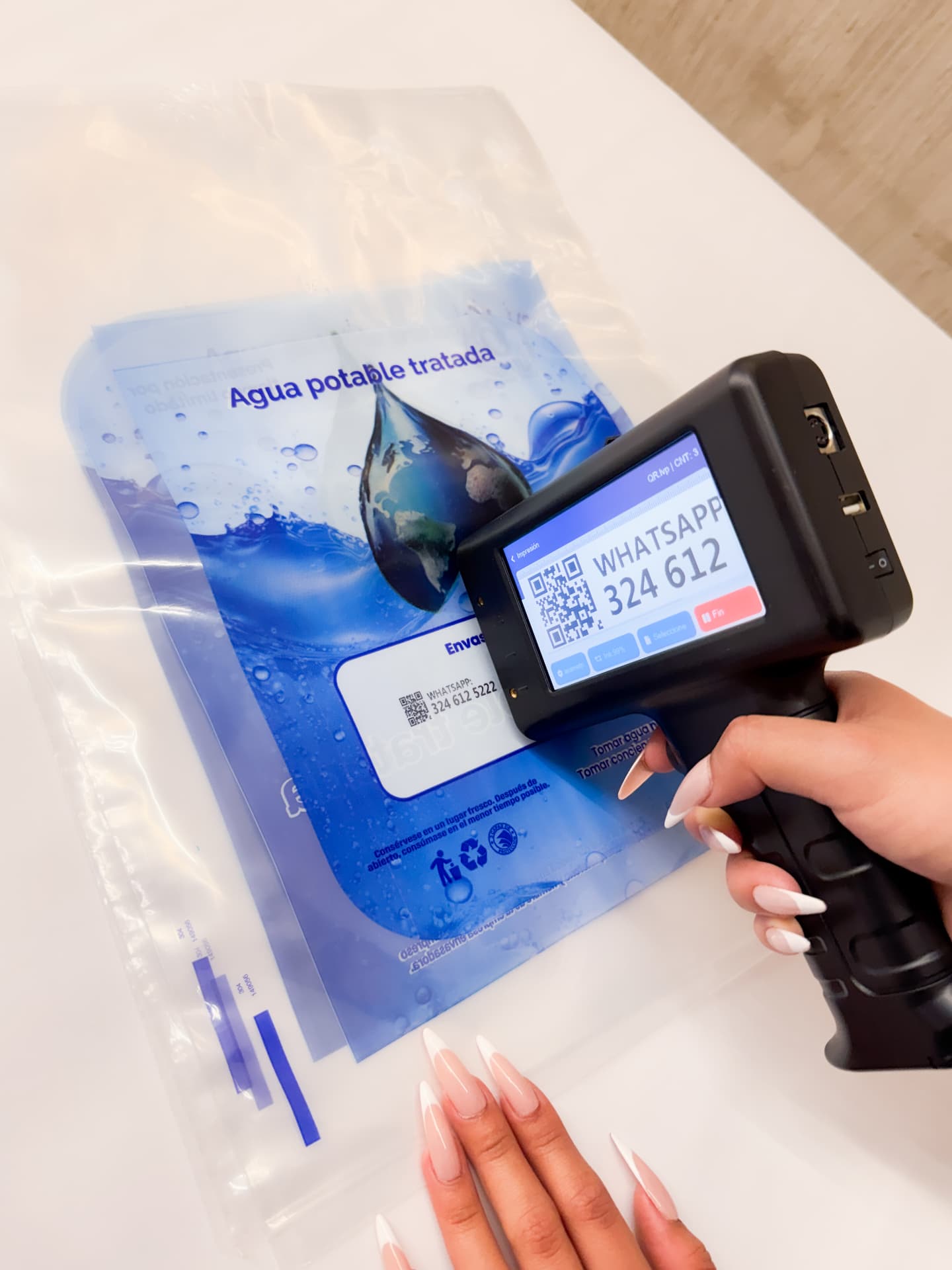 Codificadora inkjet portátil imprimiendo código QR sobre empaque plástico de agua